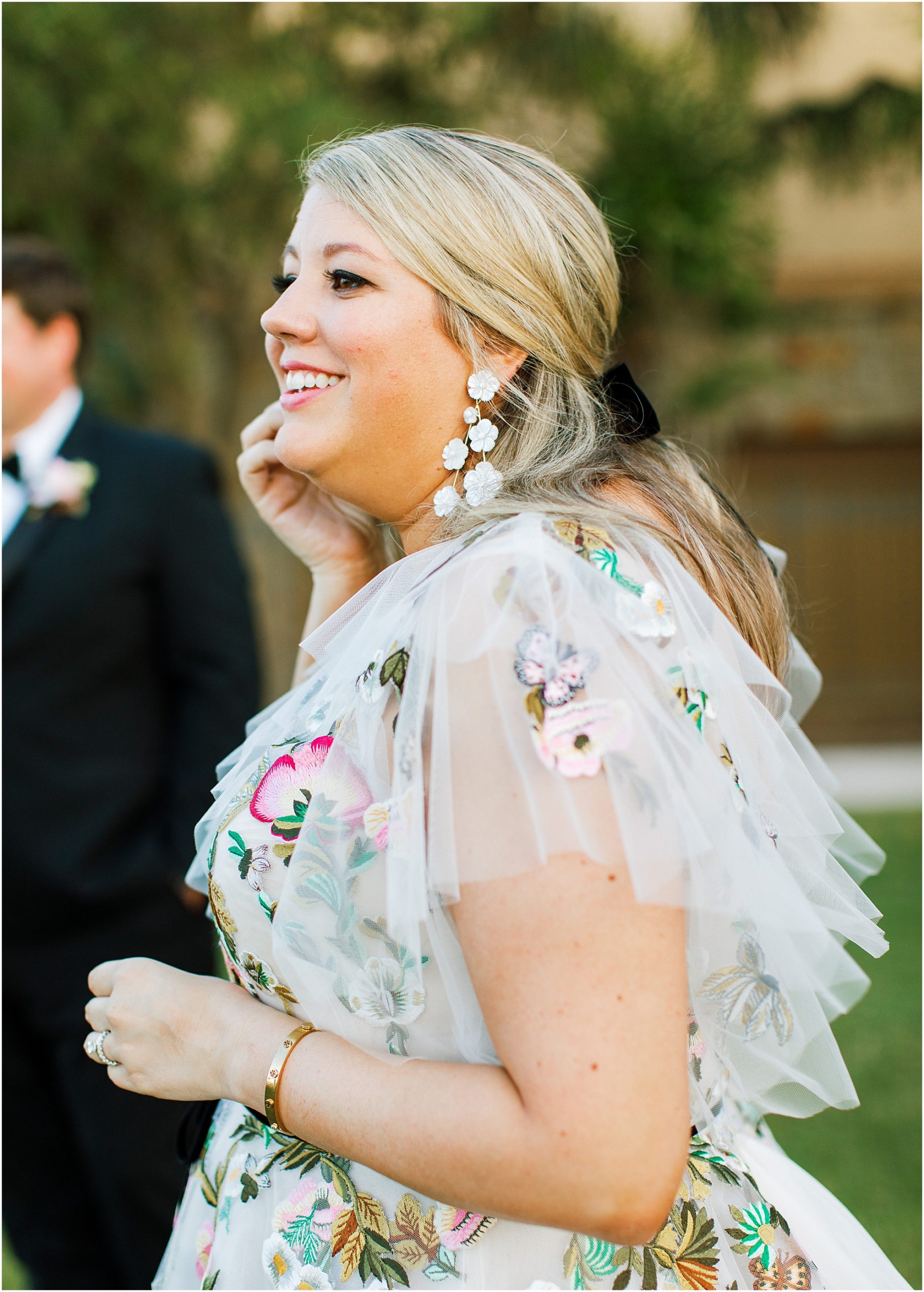 Bride in Monique Lhuillier wedding dress with bright flowers and butterflies