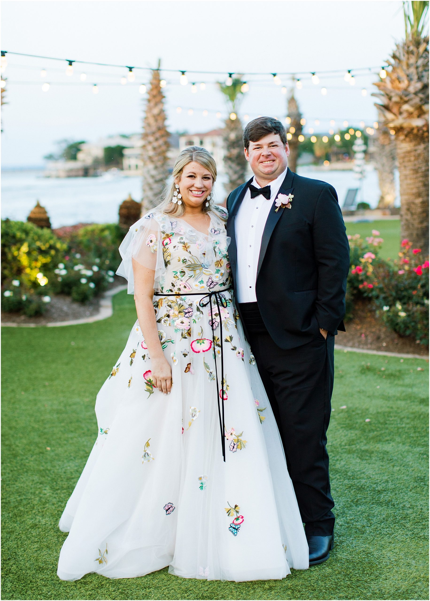 Bride in Monique Lhuillier bridal gown with butterflies anf flowers with groom wearing a black tux at horse shoe bay resort