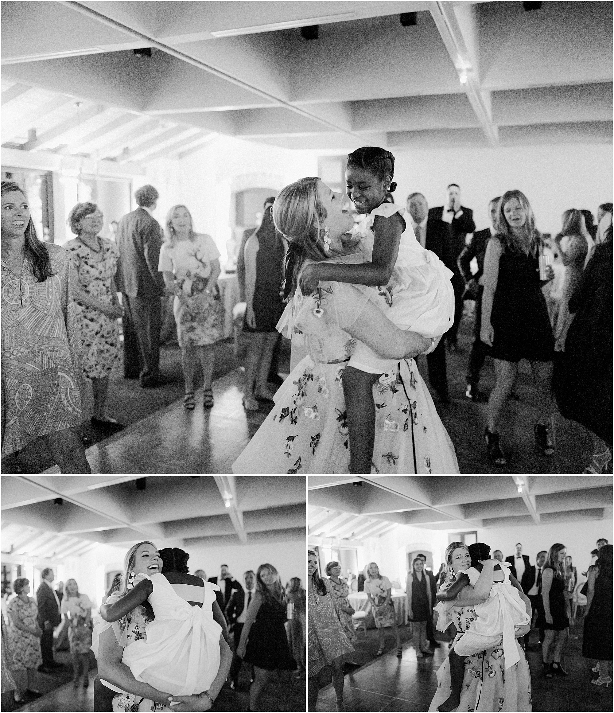 Bride dancing with flower girl in black and white at wedding reception