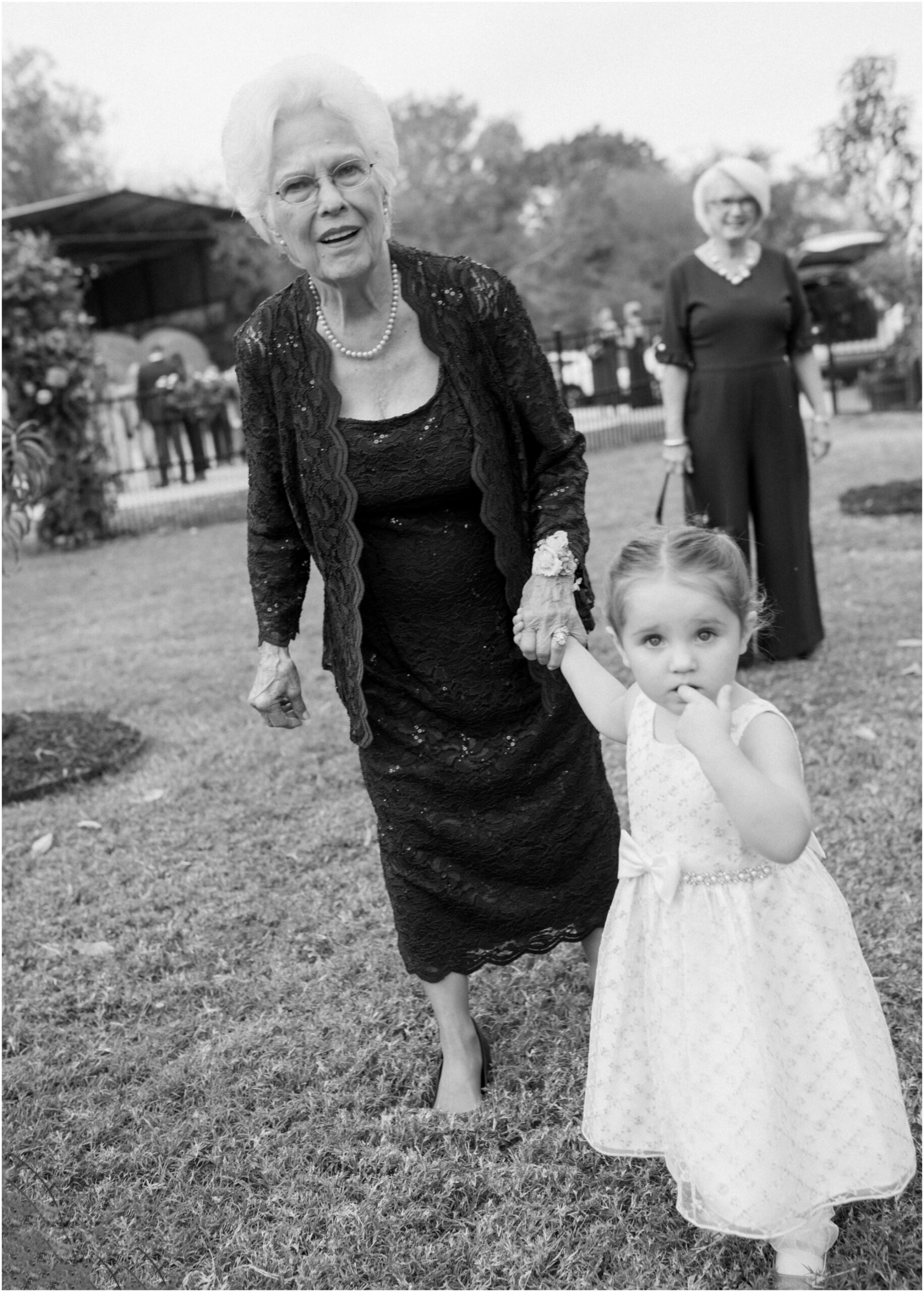 grandma holding hands with small child from an elevated backyard wedding in fort worth, Texas