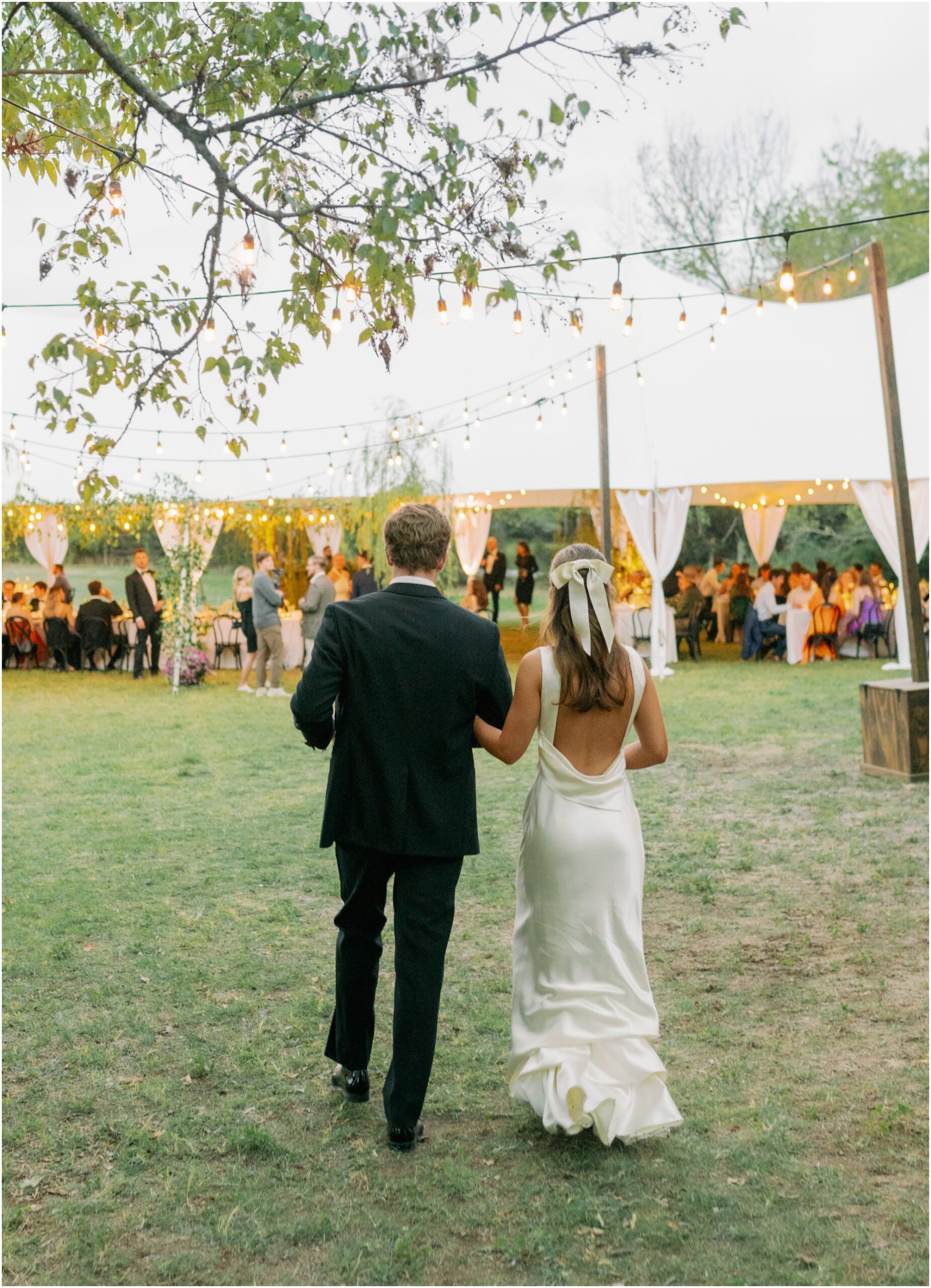 bride and groom walking into their sailcloth tent wedding