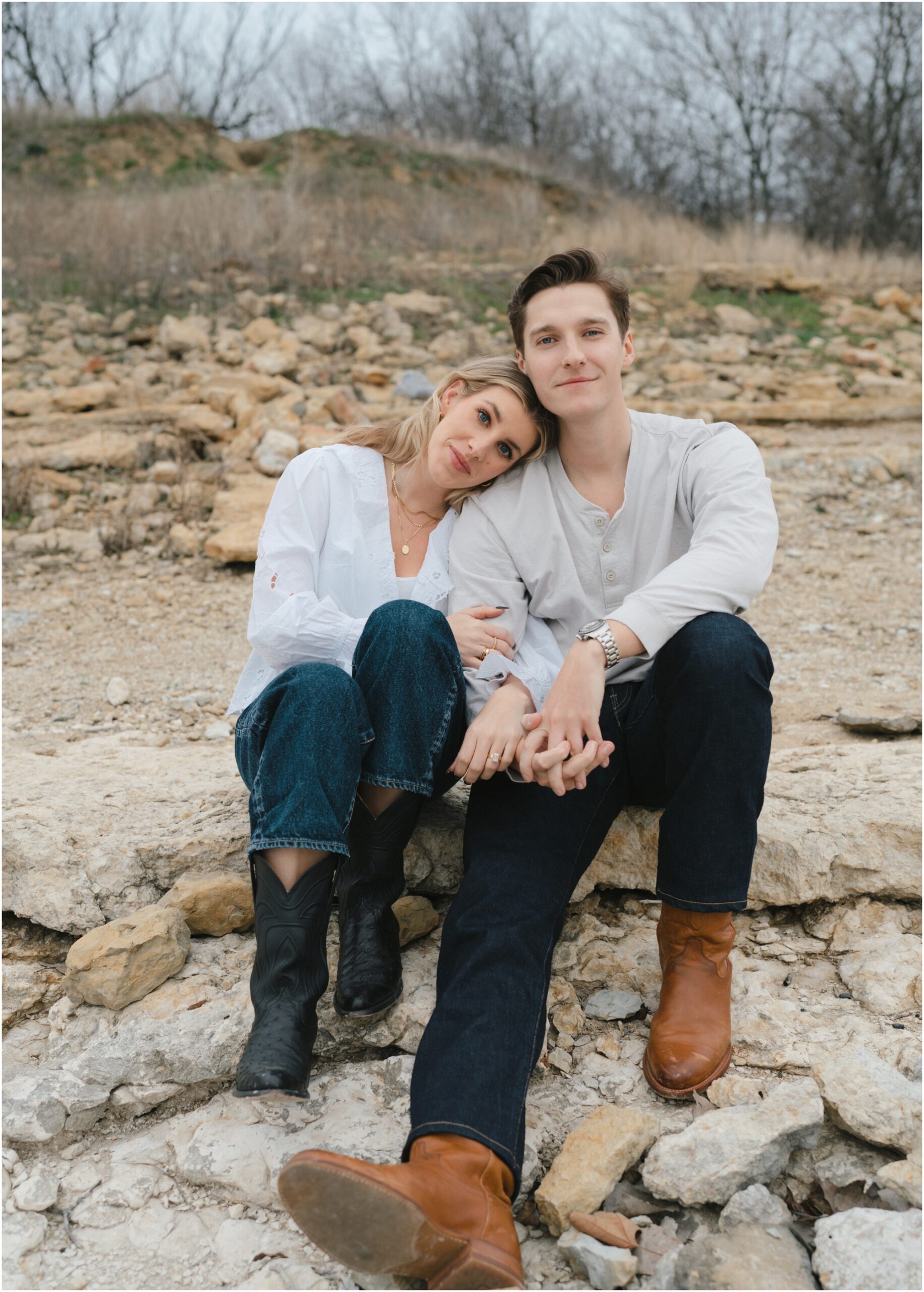 couple sitting together on rocks in fort worth texas engagement session