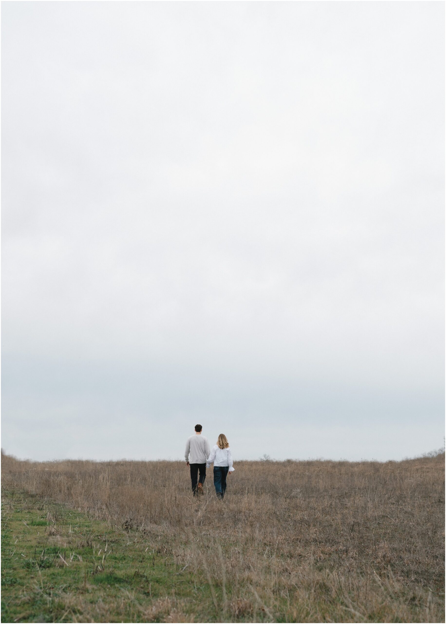 couple walking in a field in fort worth texas engagement session