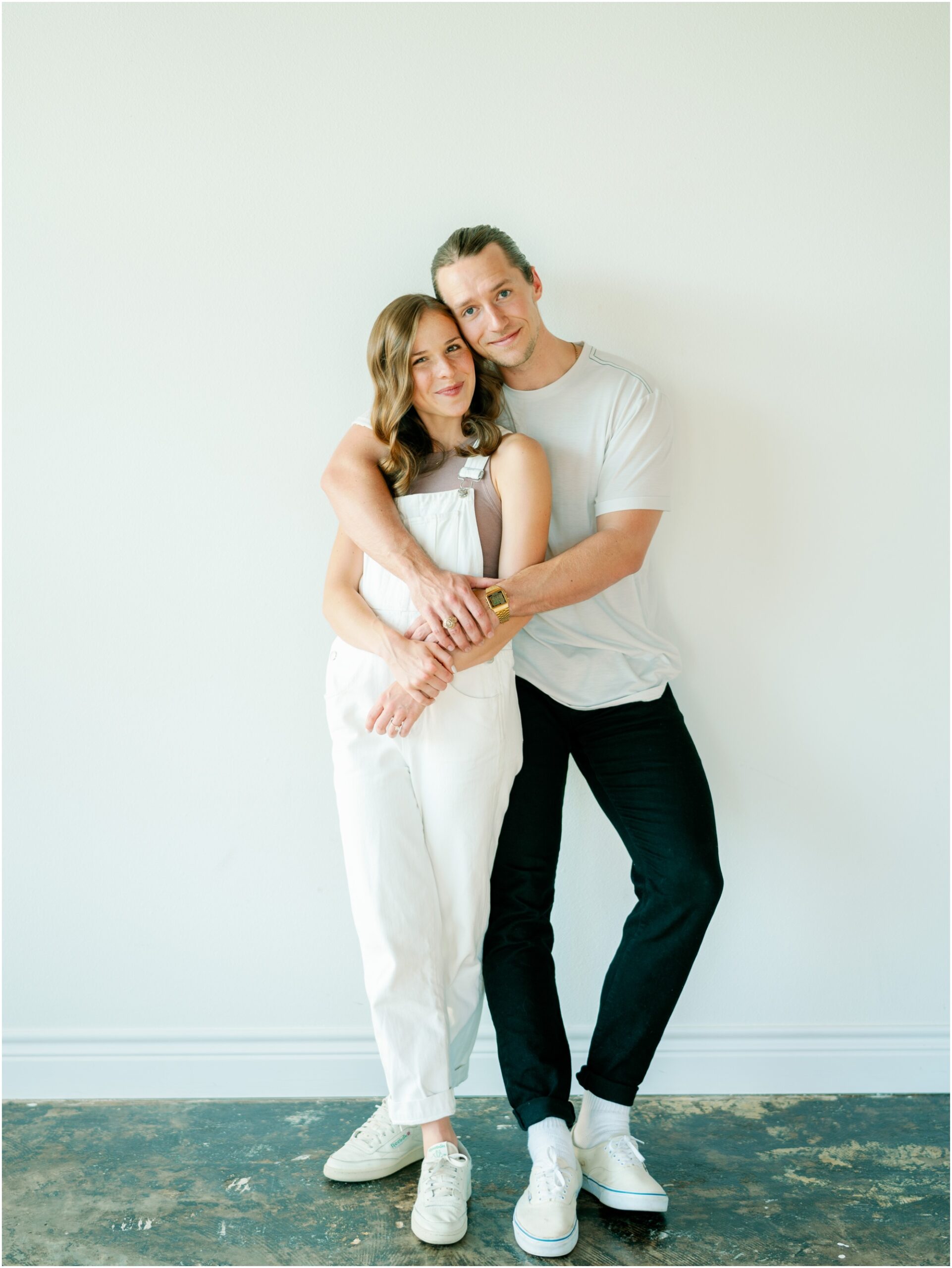 Couple leaning on wall in a studio