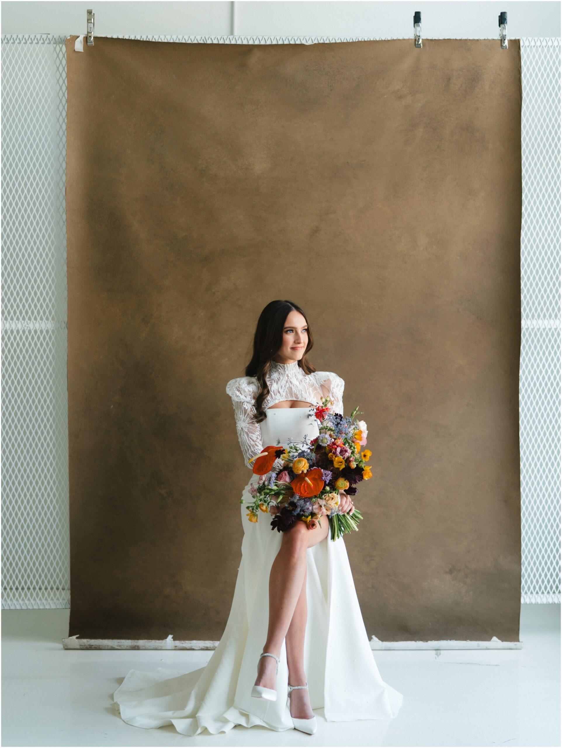 bridal session in the studio with a brown backdrop and colorful bouquet