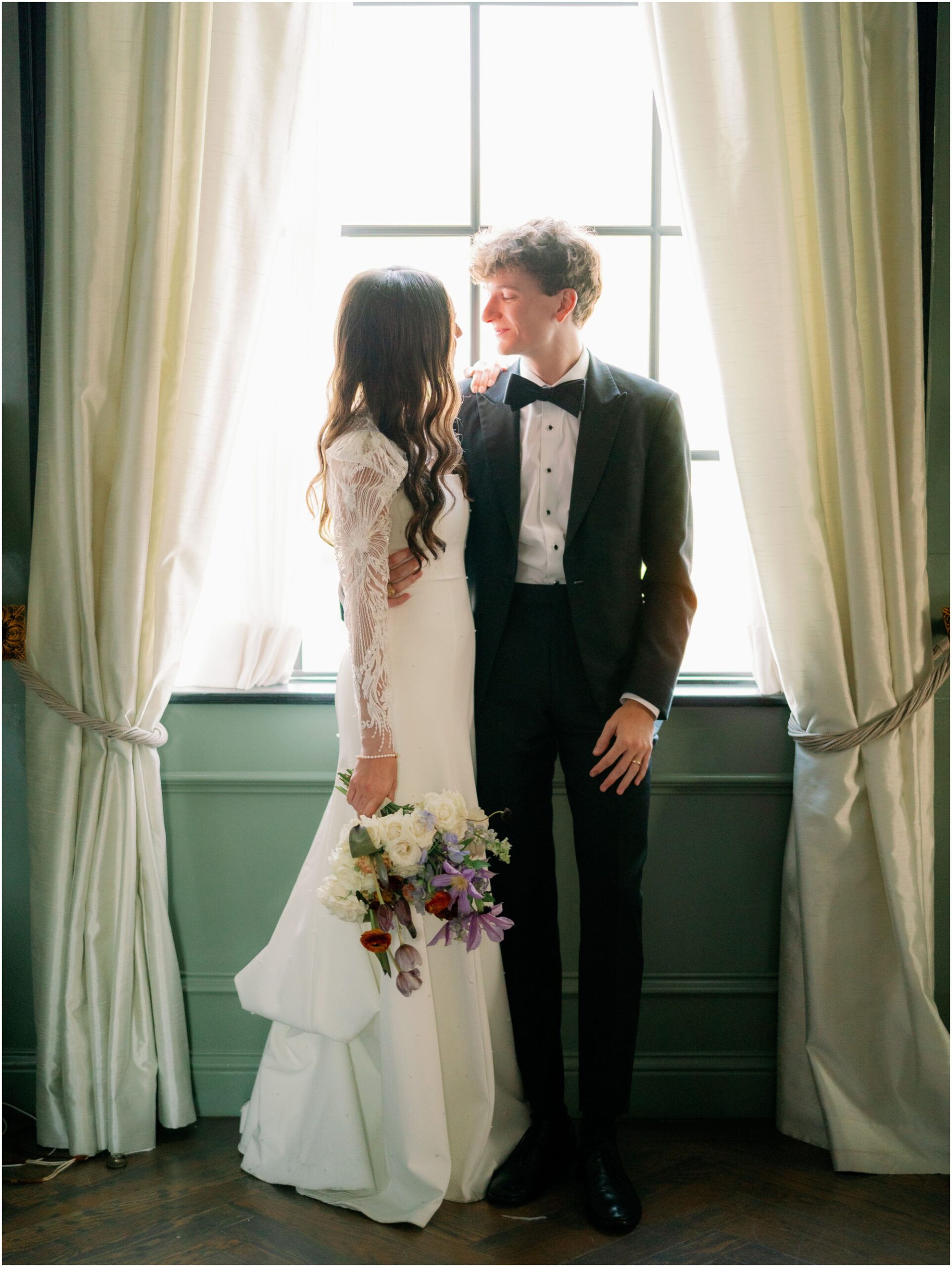 bride and groom portraits in front of window